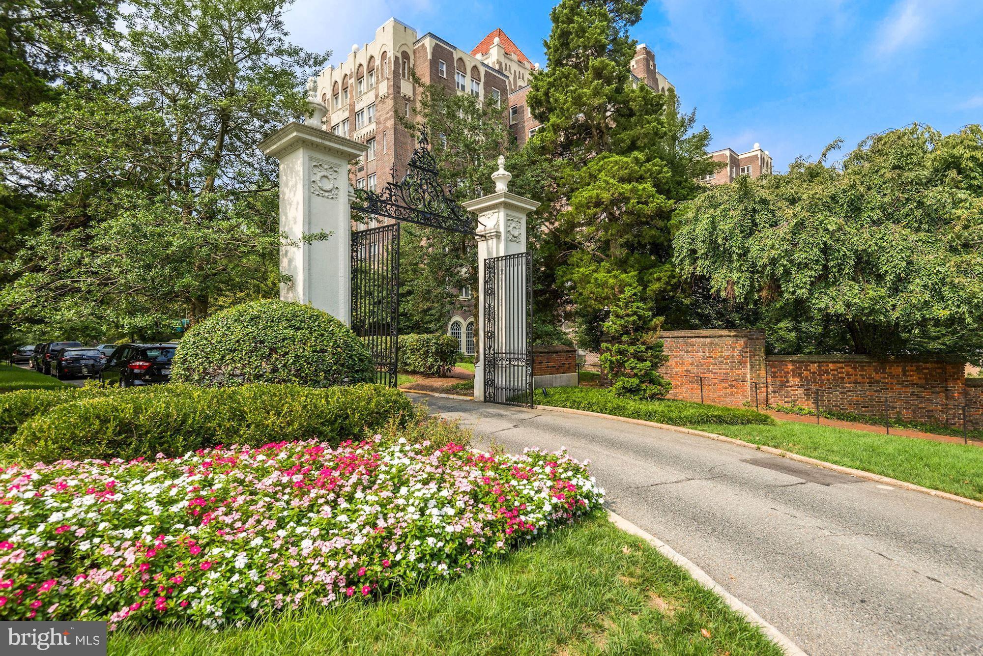 a front view of a house with a yard and fountain in middle