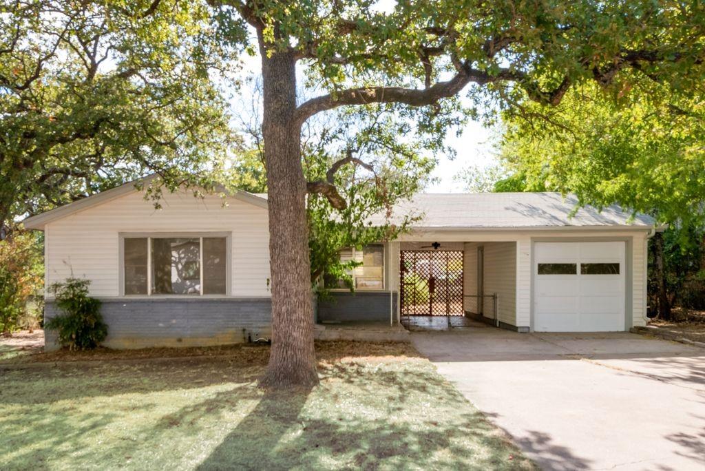 a view of a house with a tree in front of it