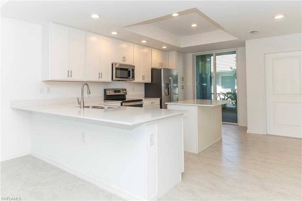 a kitchen with stainless steel appliances granite countertop a sink a stove and a refrigerator