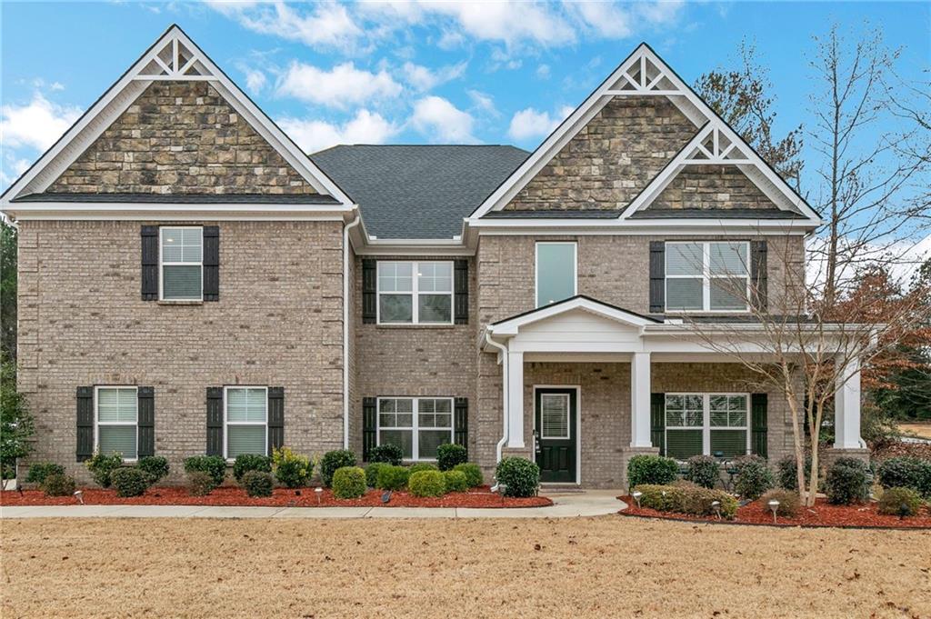 front view of a brick house with a yard