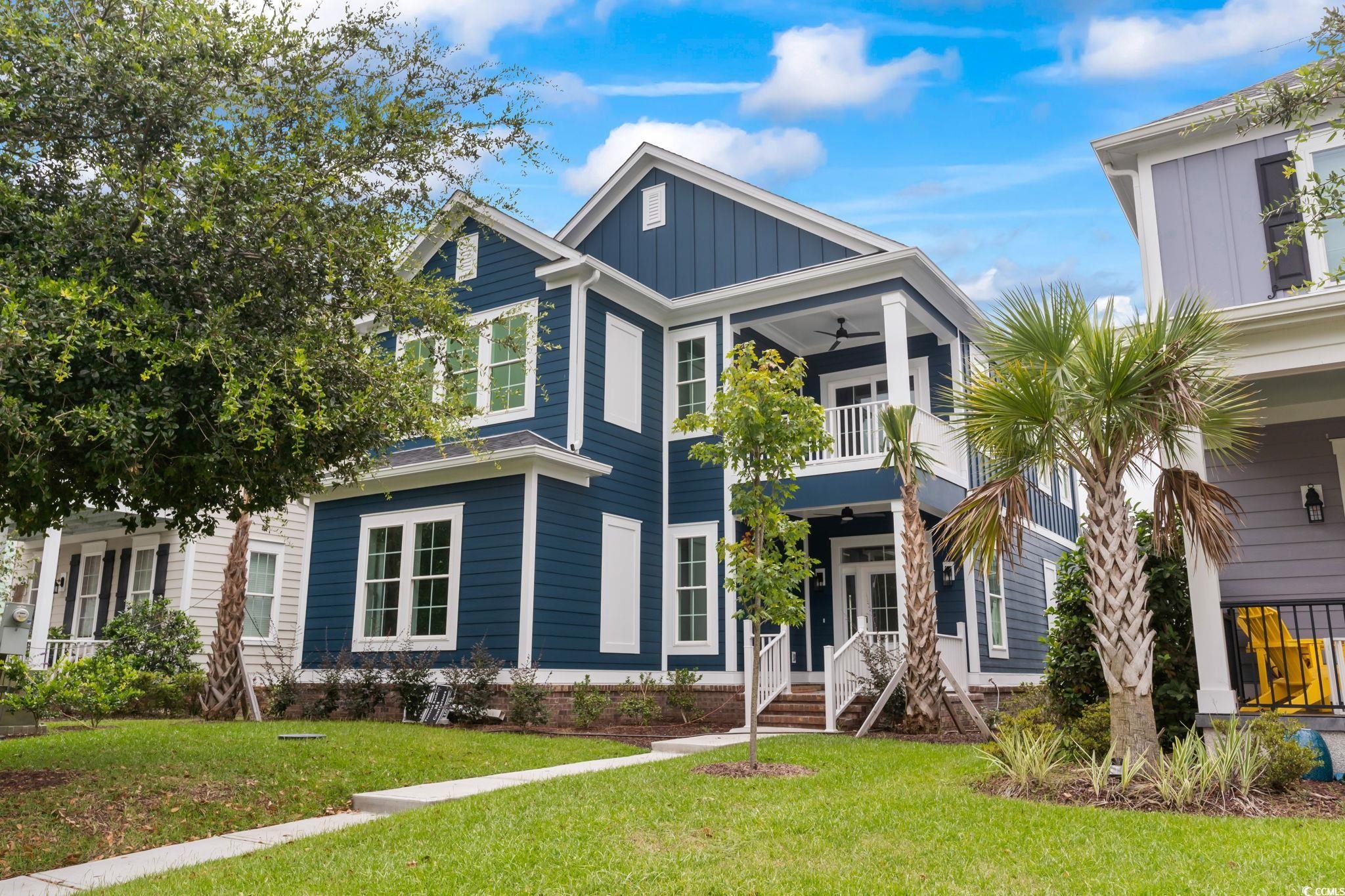 View of front of home with a front lawn and a balc