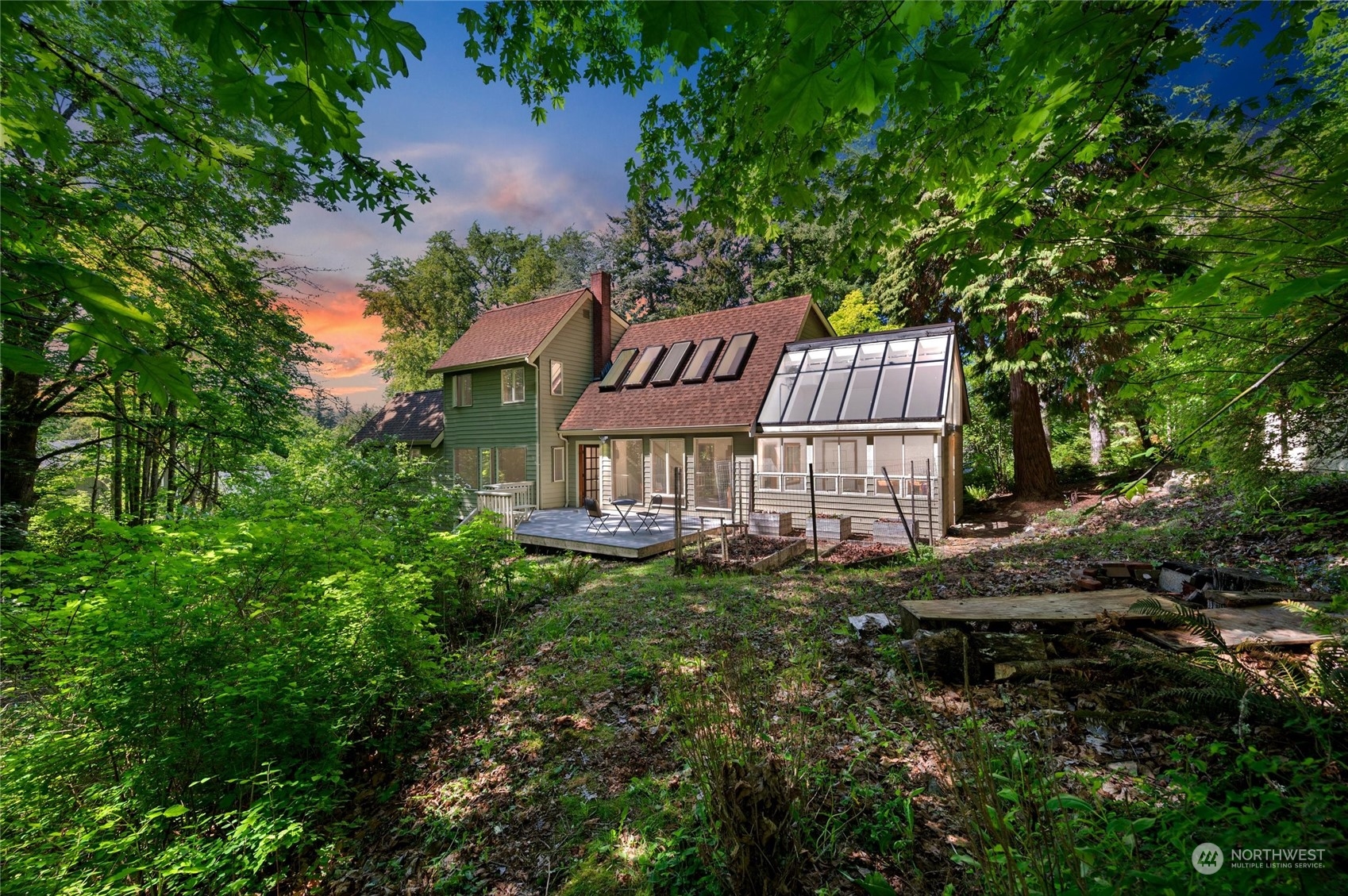 a view of a house with a yard and large trees