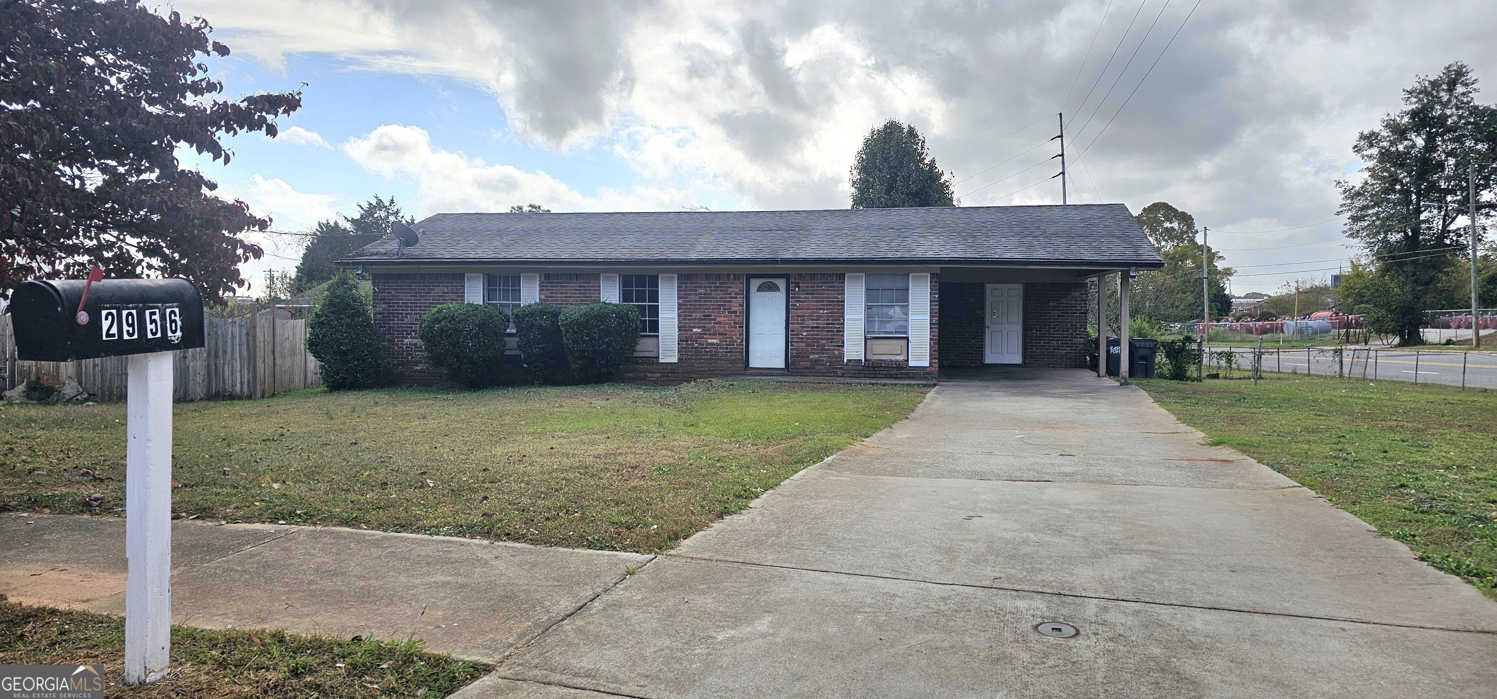 a front view of a house with a yard and potted plants