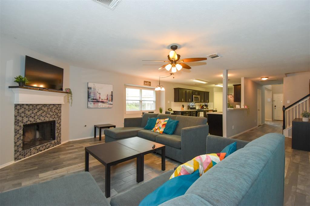 a living room with furniture a flat screen tv and a fireplace