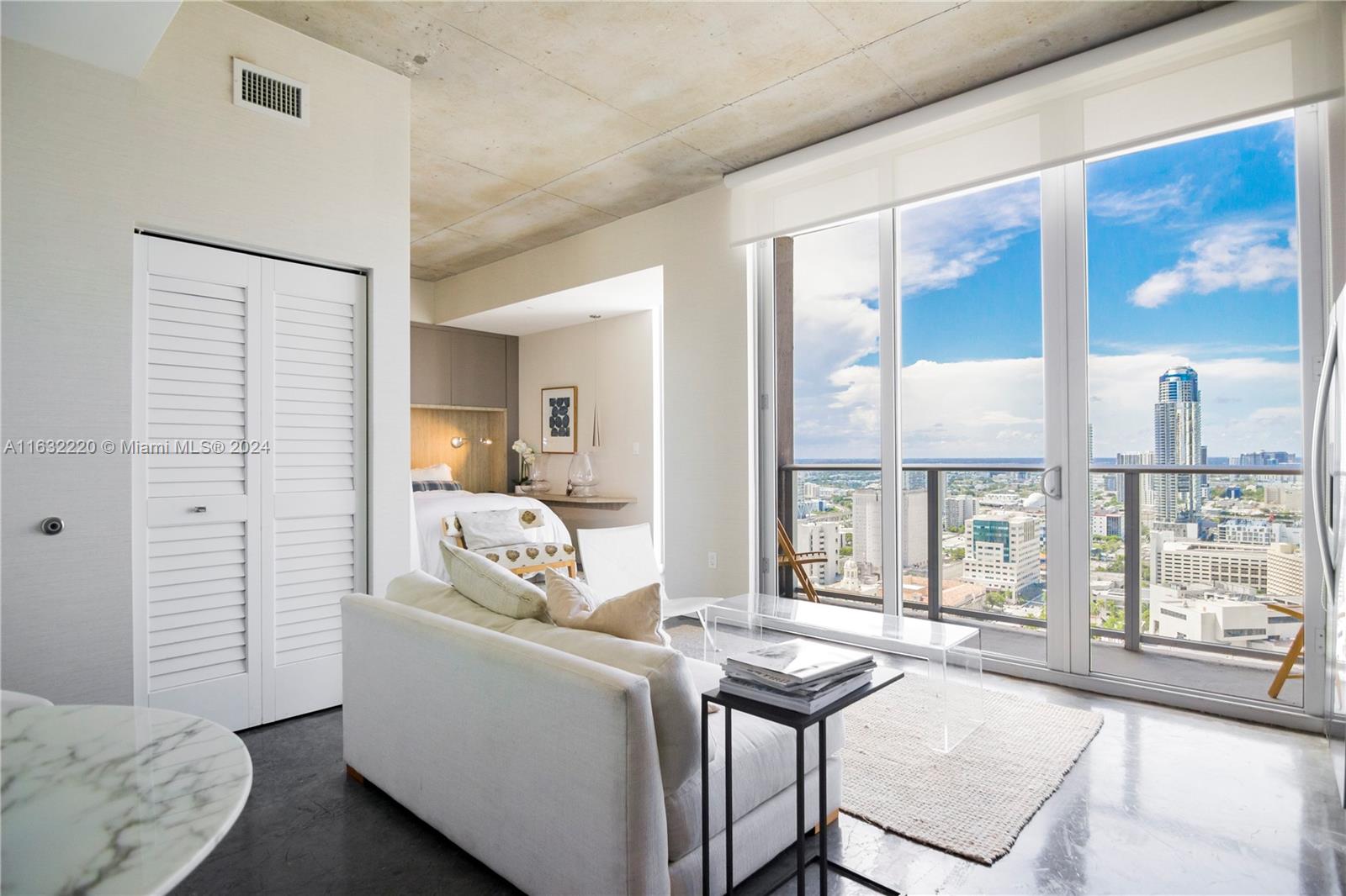 a living room with furniture and a floor to ceiling window