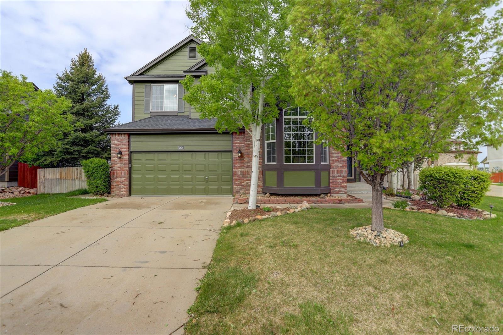 front view of a house with a yard and a garage