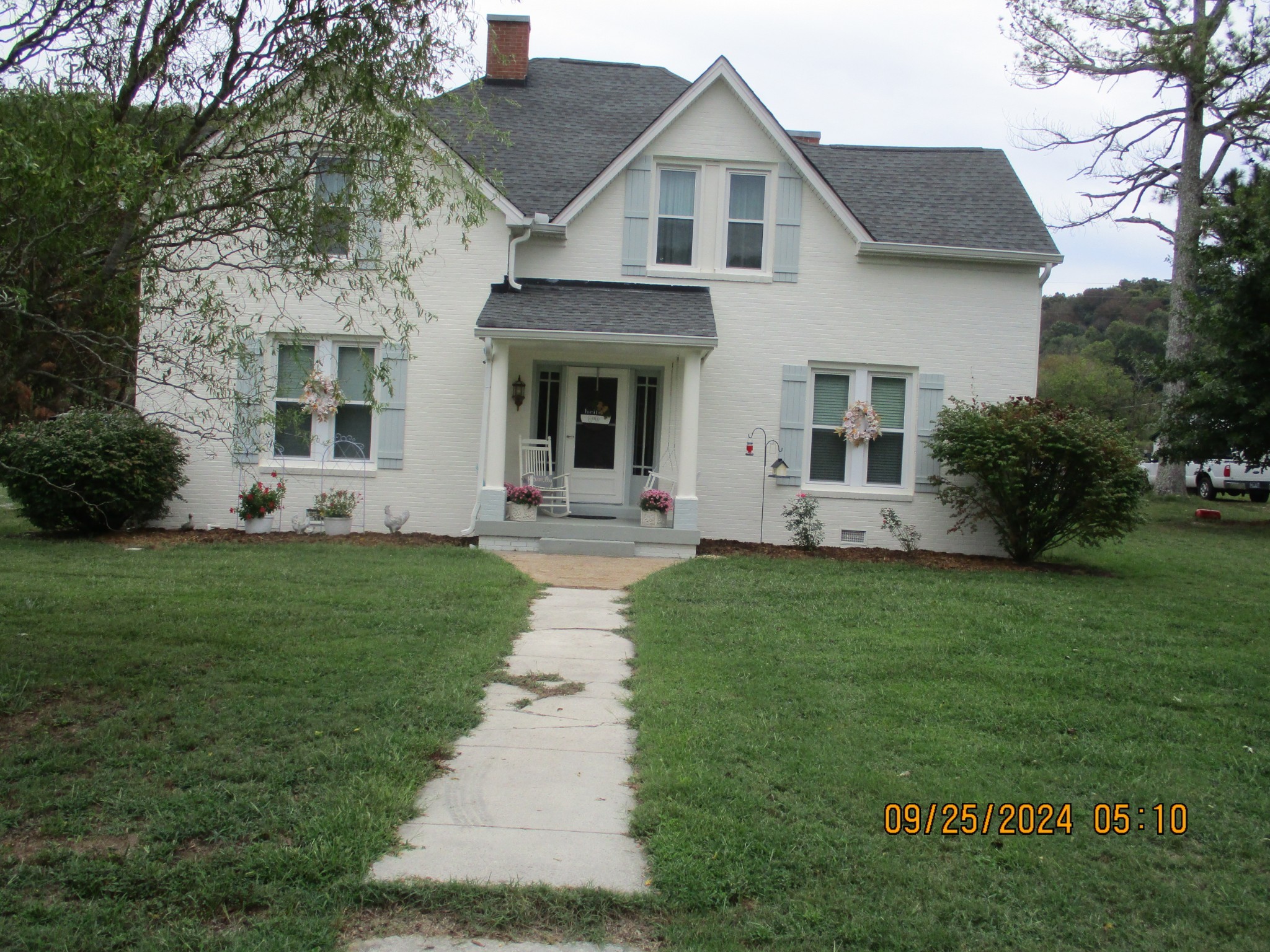 a front view of a house with a garden and plants