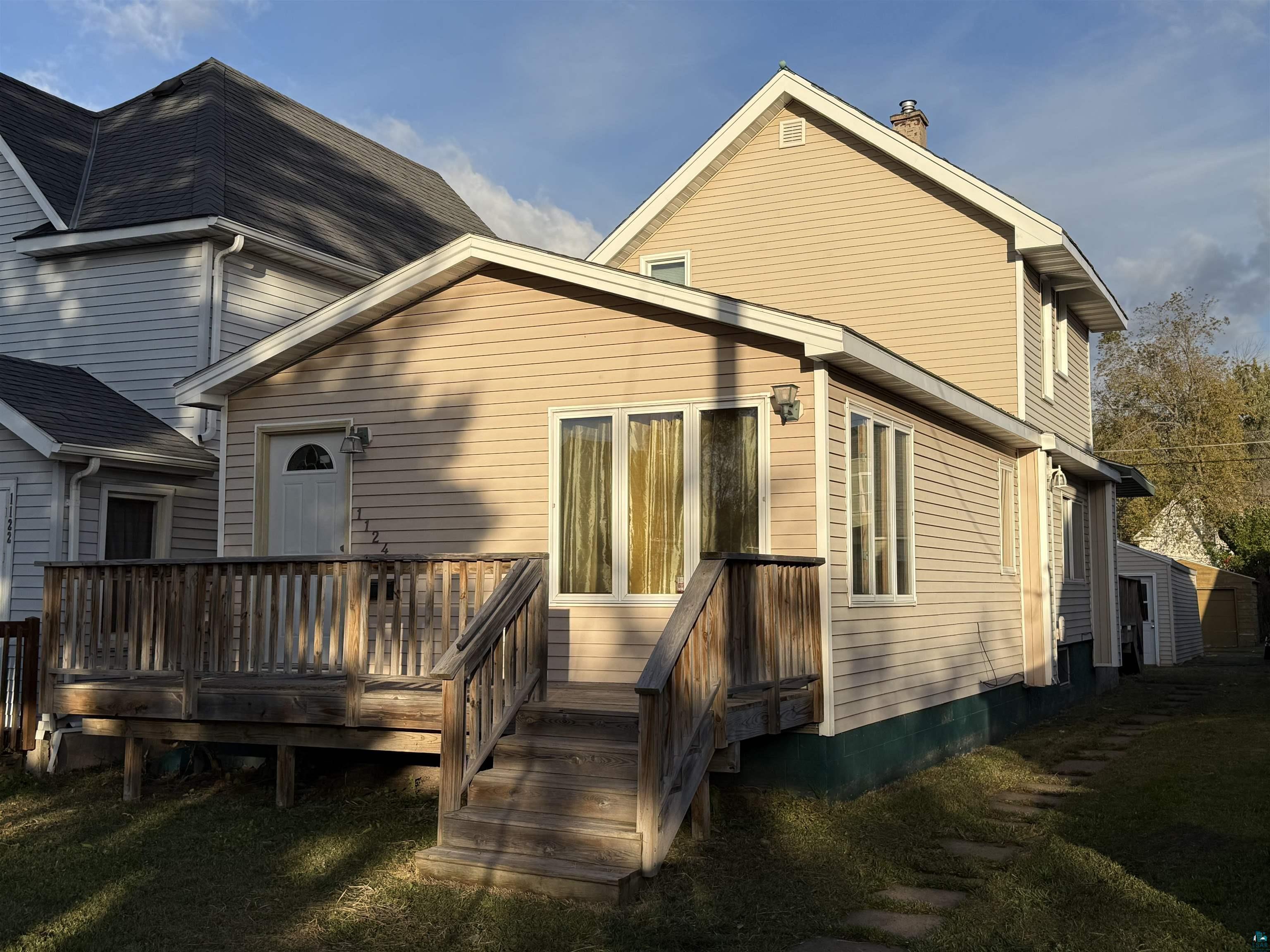 Back of property with a deck and a lawn