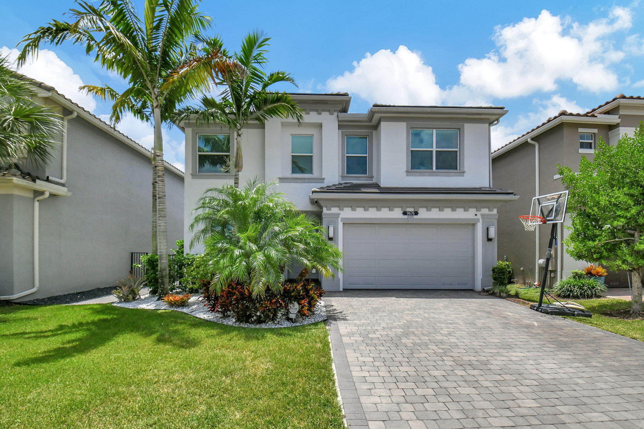 a front view of a house with a garden and a garage