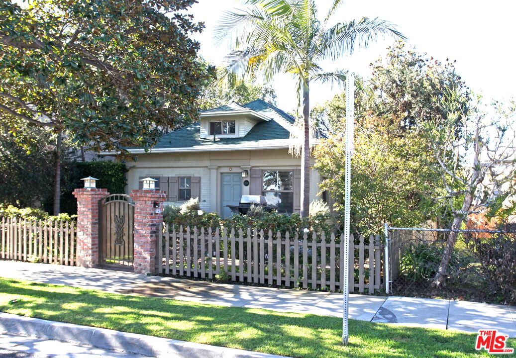 a front view of house with a garden and trees