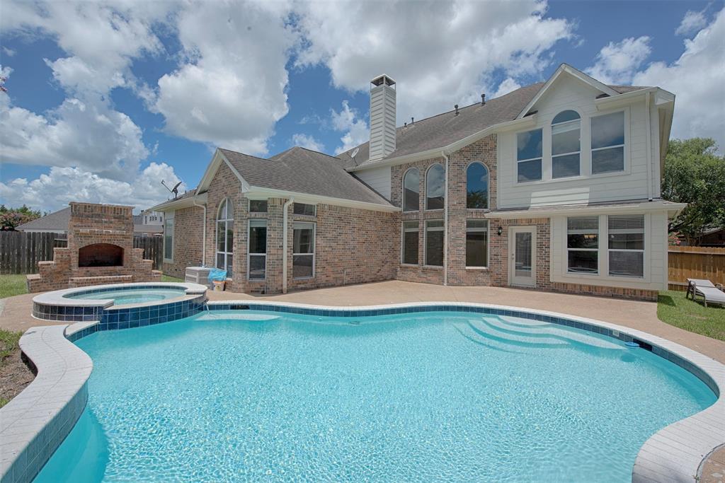 a front view of a house with swimming pool having outdoor seating