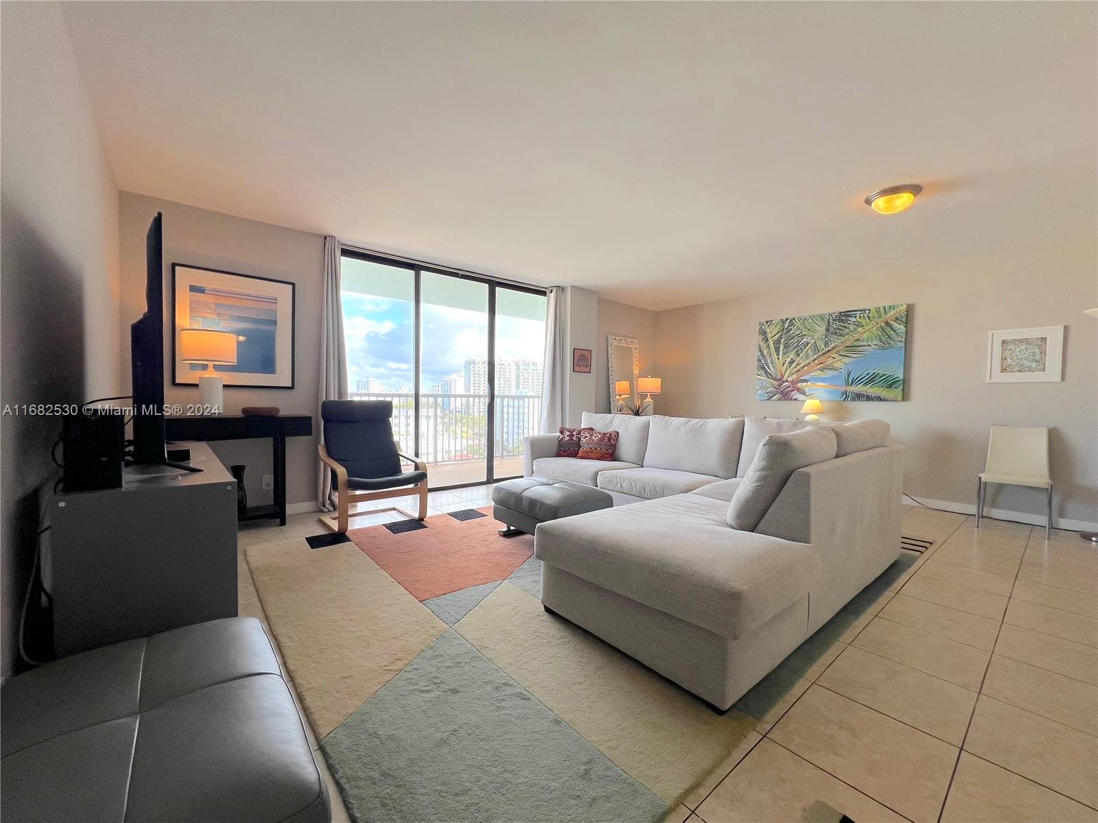 a living room with furniture and large windows