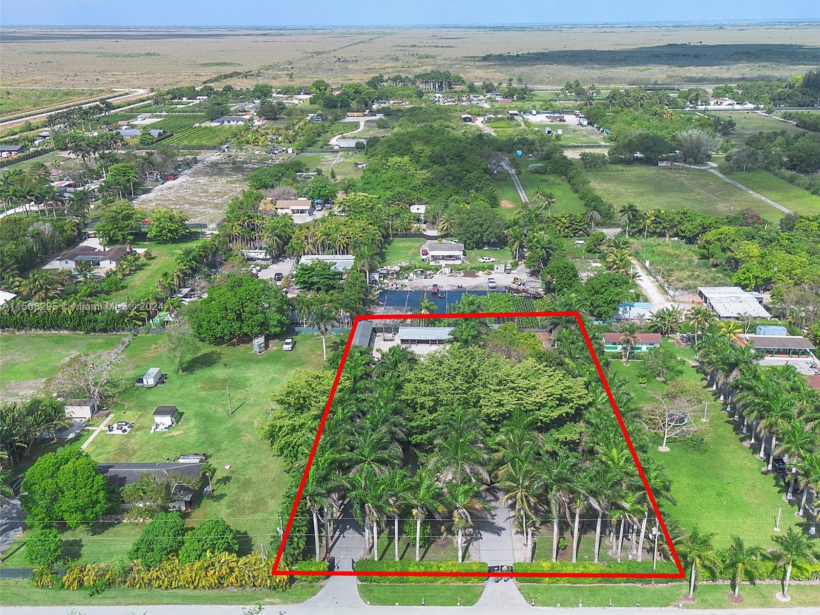 an aerial view of residential houses with outdoor space and trees