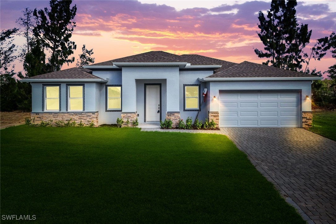 a front view of a house with a garden and yard