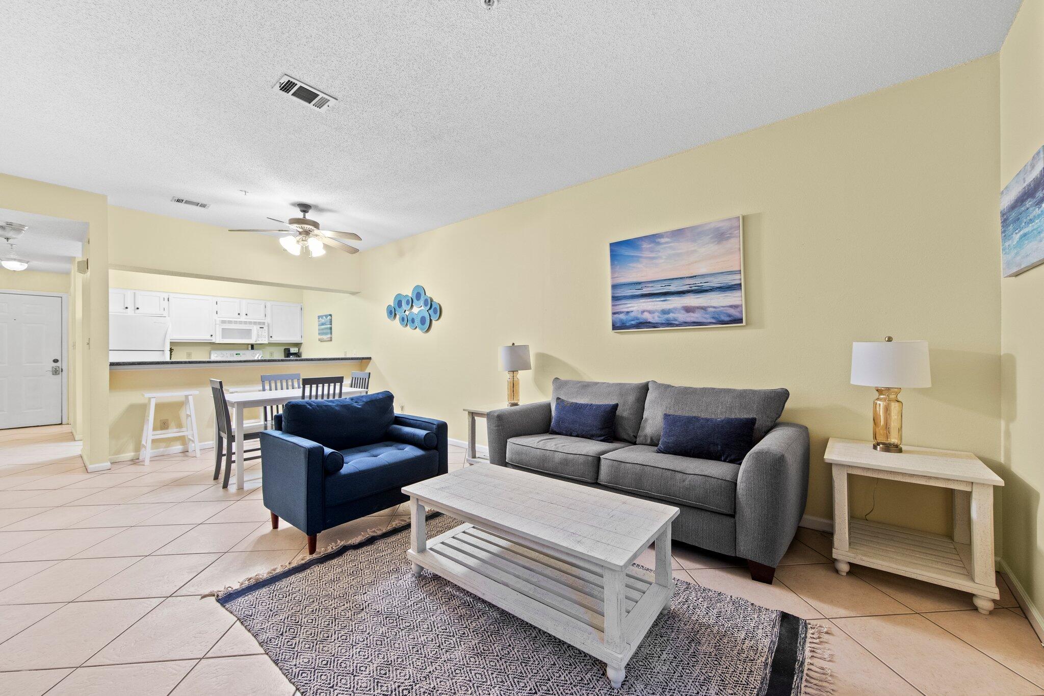 a living room with furniture and a view of kitchen