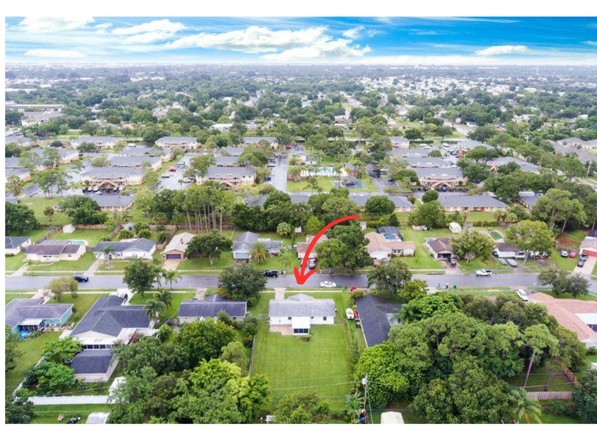 an aerial view of residential houses with outdoor space and trees