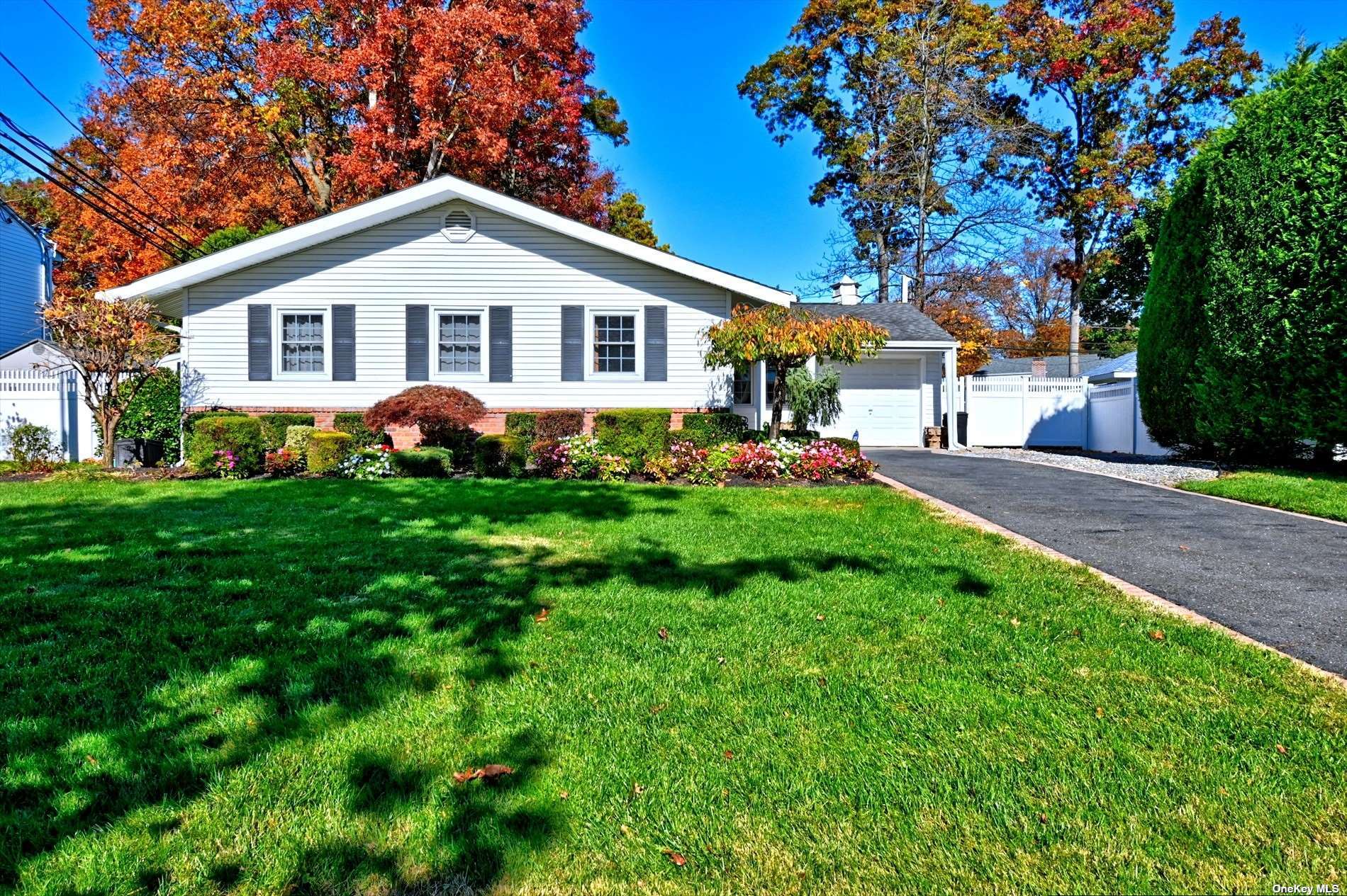 a front view of a house with a yard and trees