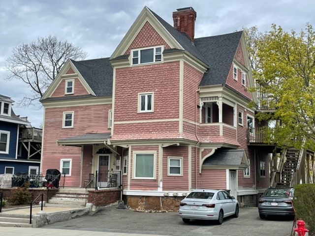 a front view of a house with cars parked