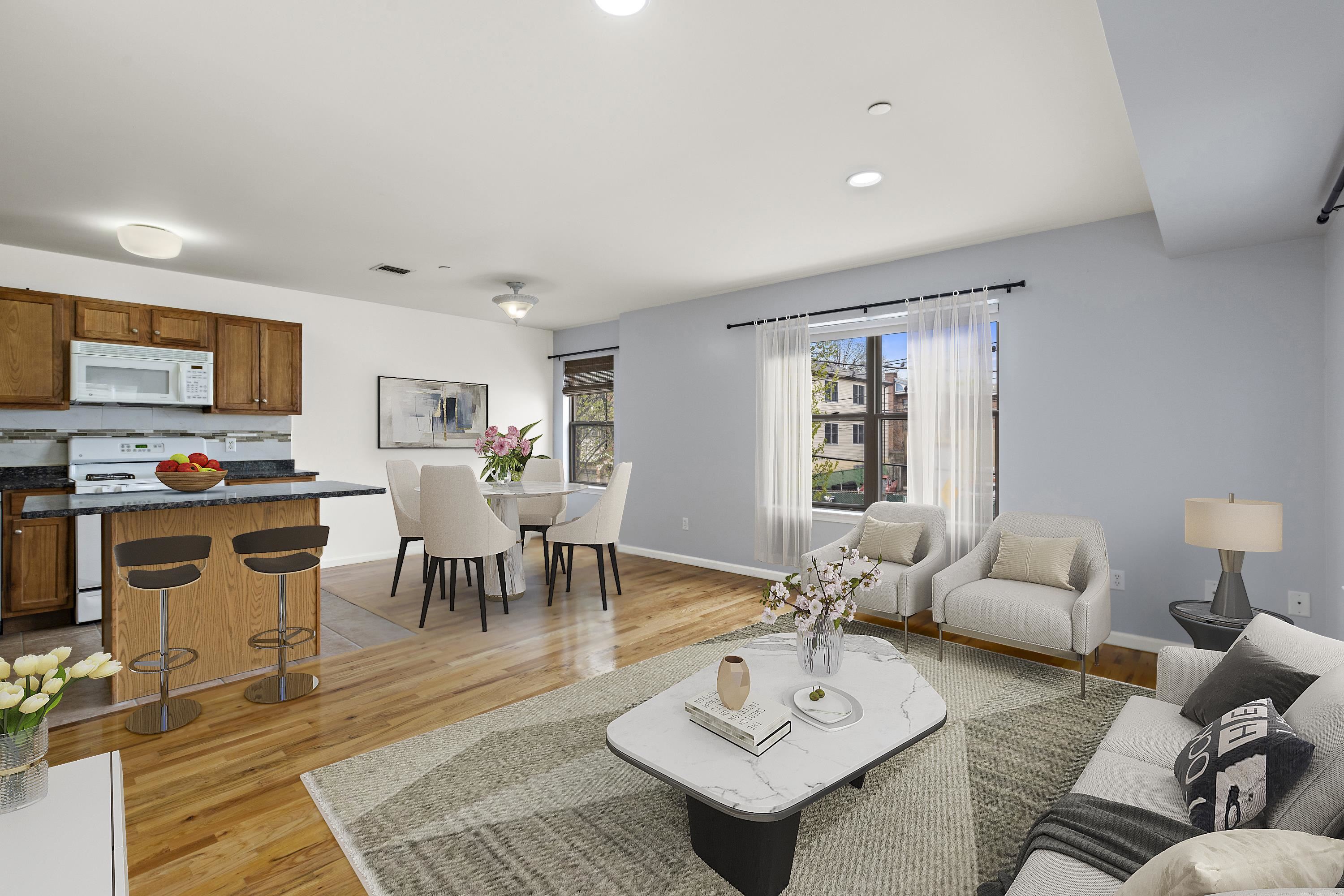 a living room with furniture kitchen view and a window