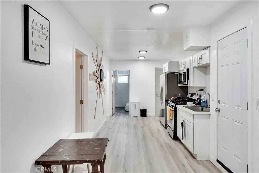 a view of a kitchen with refrigerator and wooden floor