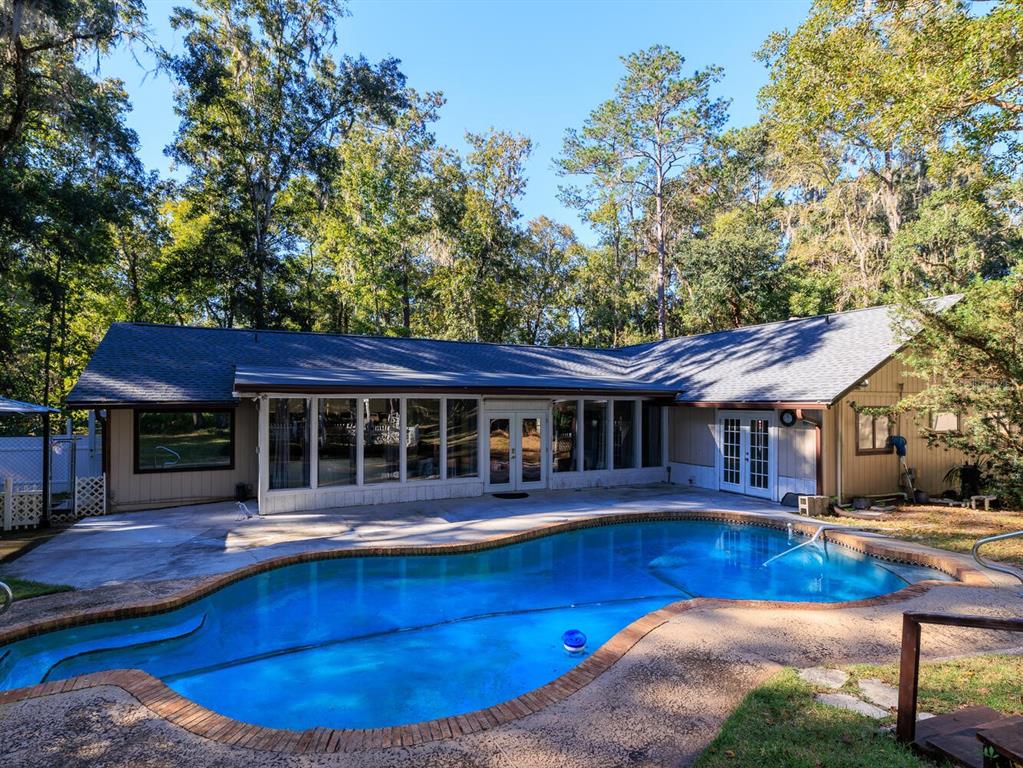 swimming pool view with a seating space and a garden view