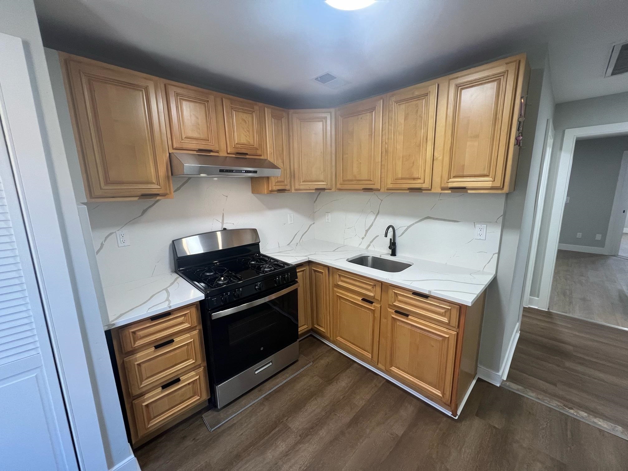 a kitchen with wooden cabinets and a stove top oven