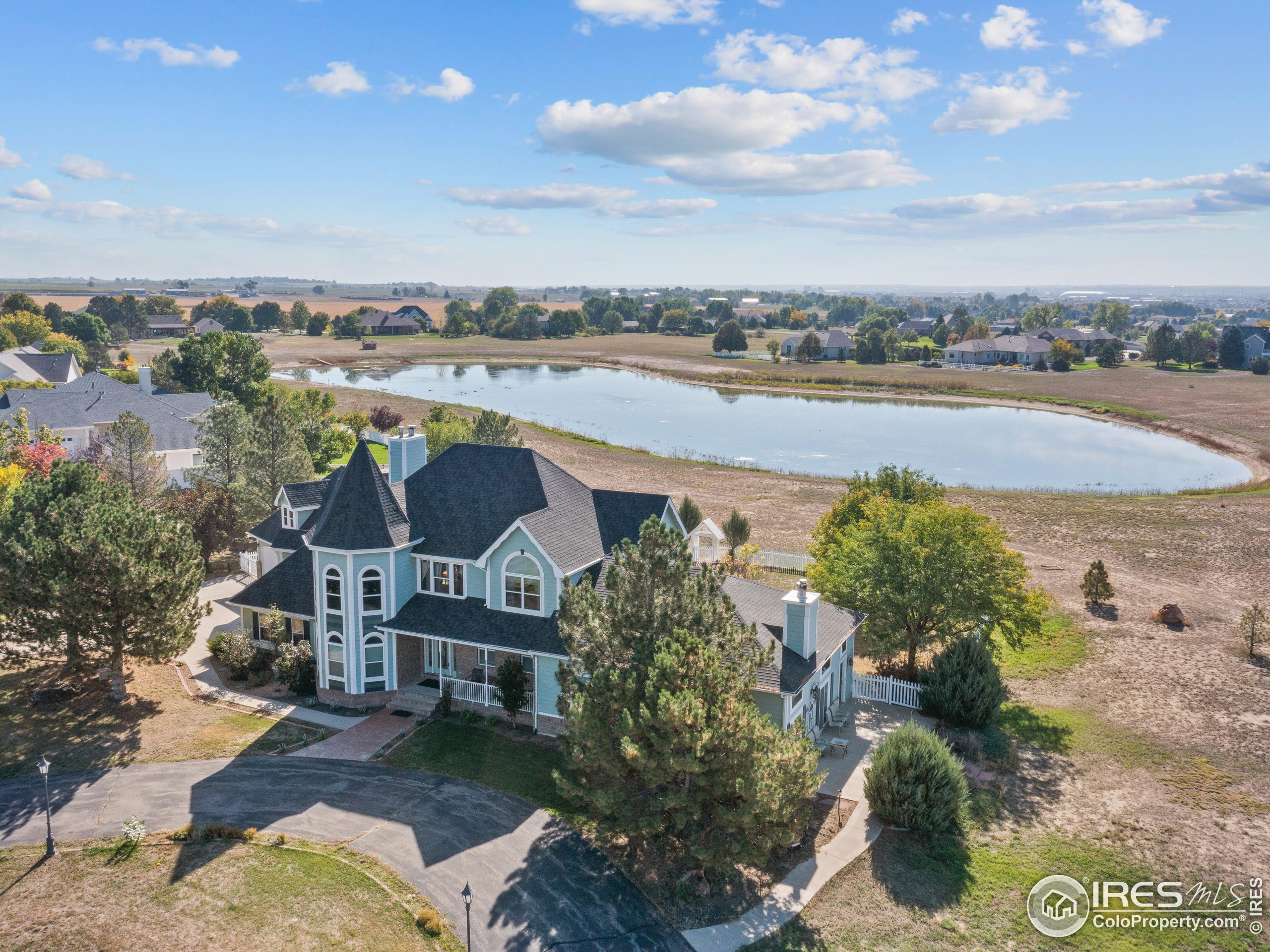 an aerial view of a house with a yard and lake view