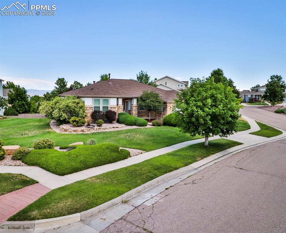 a view of a big house with a big yard and potted plants