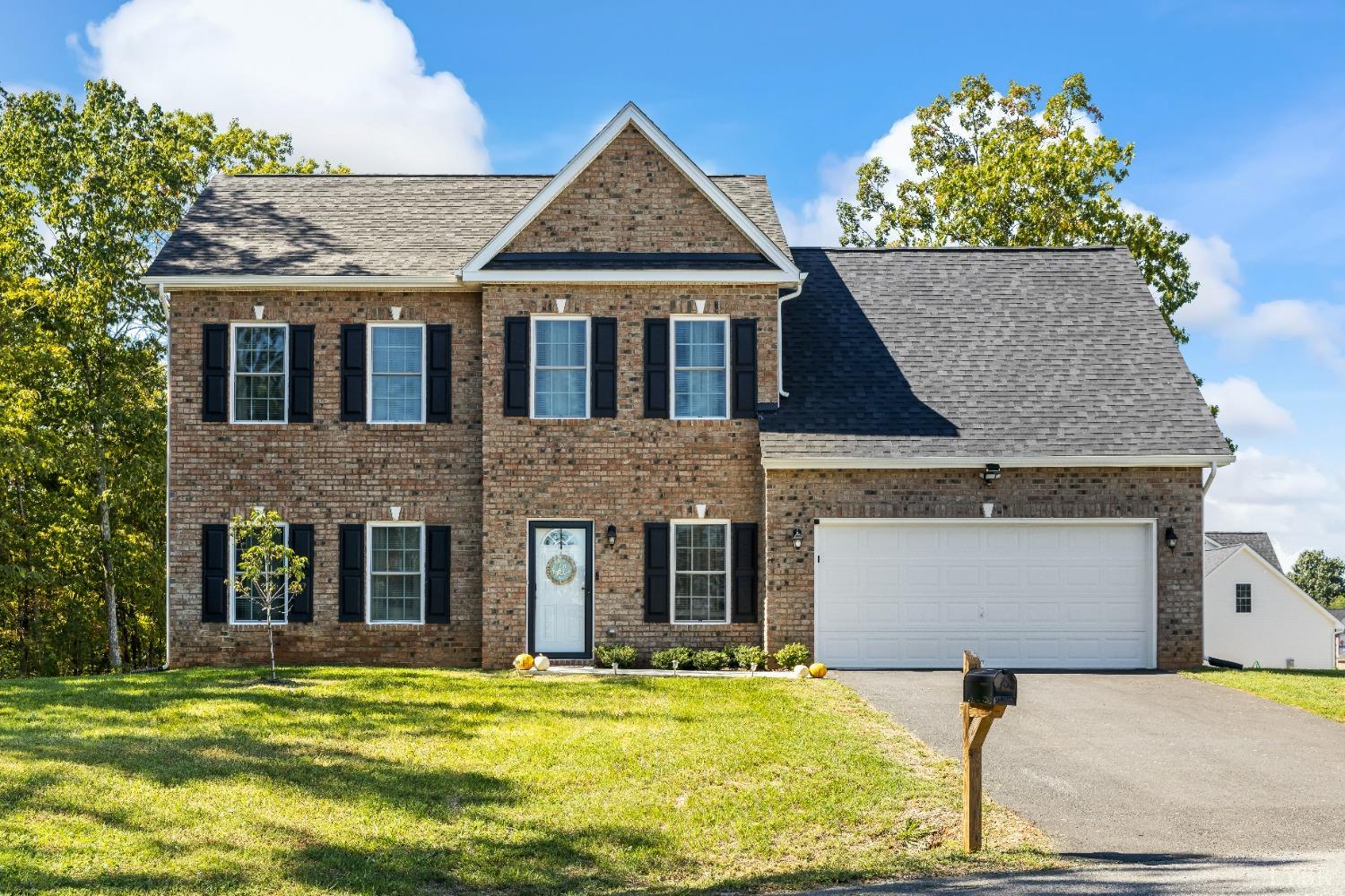 a front view of a house with a garden and yard