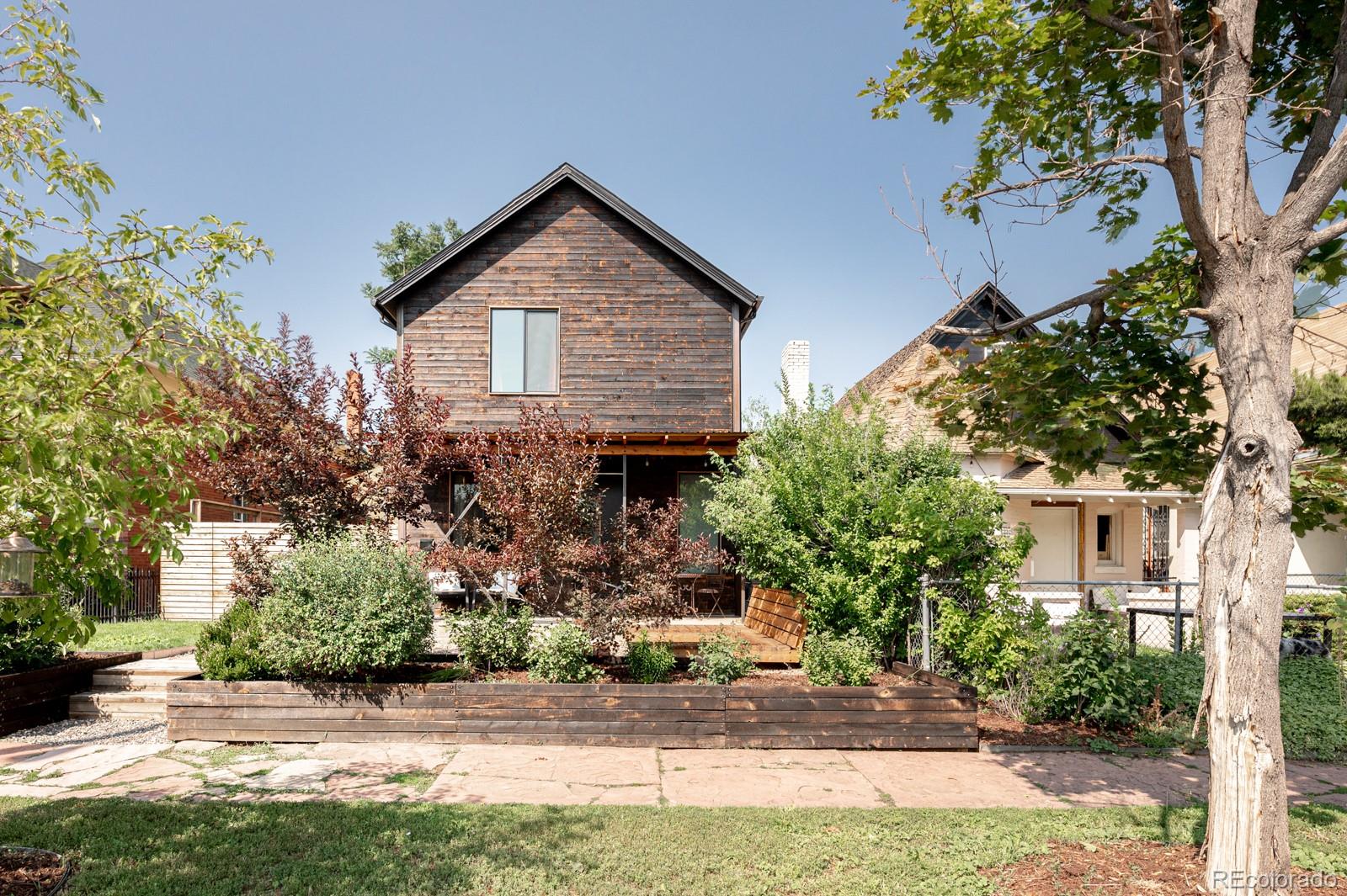 a front view of a house with a yard and tree