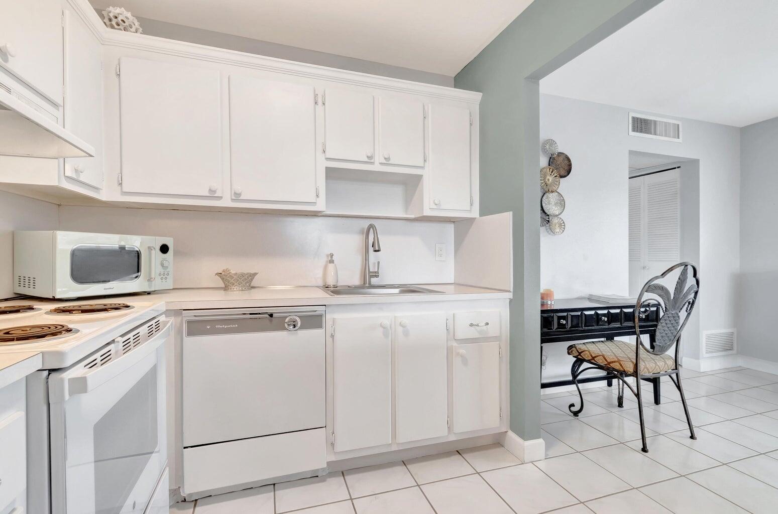 a kitchen with cabinets appliances and a dining table