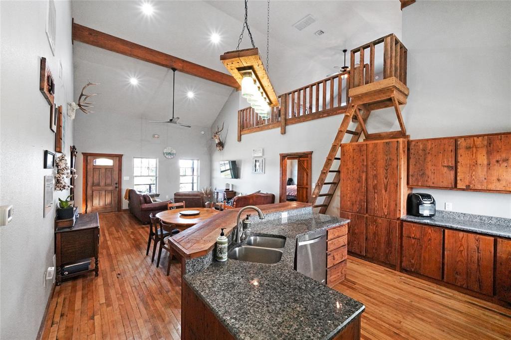 a very nice looking living room with a dining table chairs with wooden floor