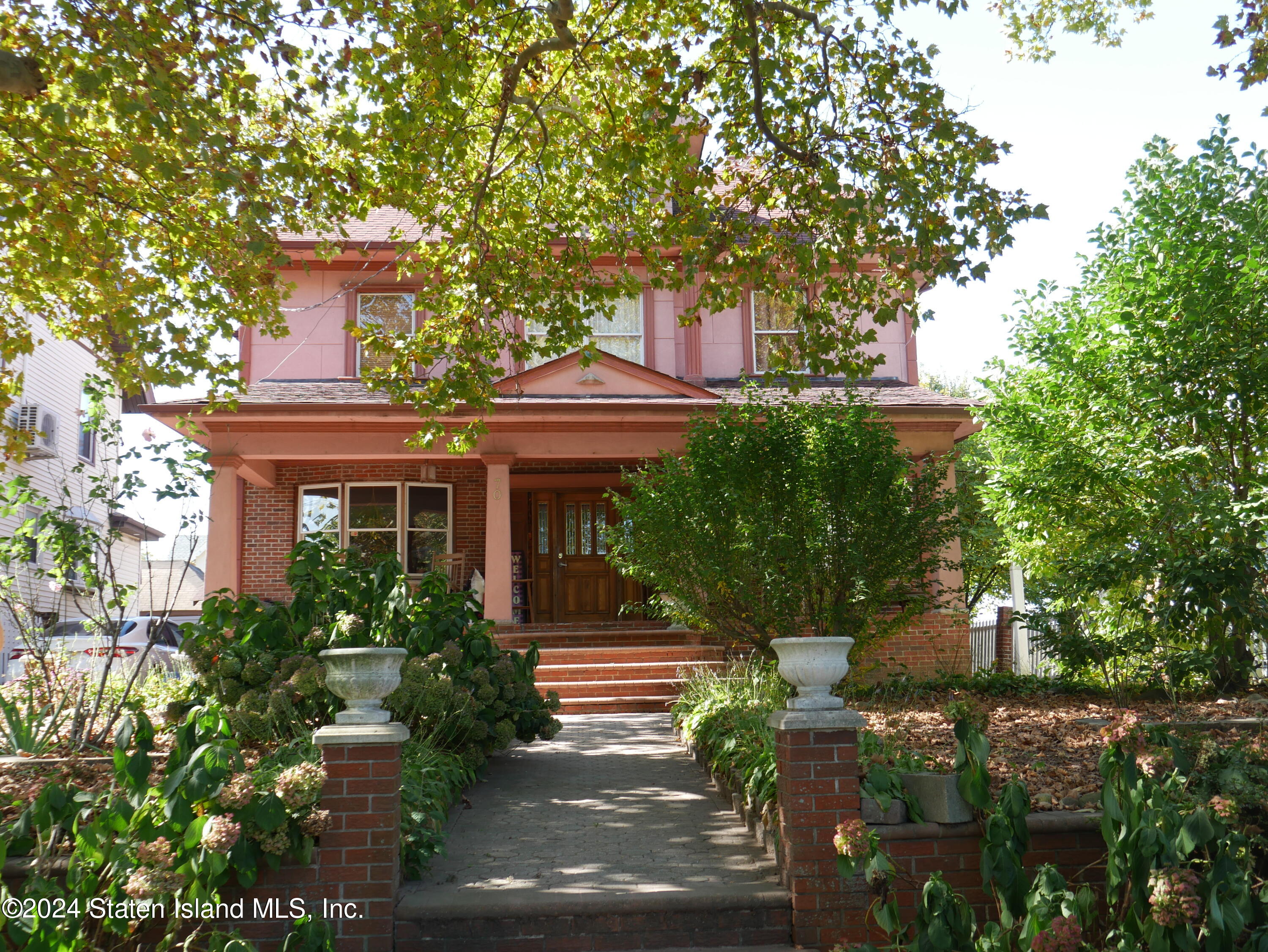 a front view of a house with a tree