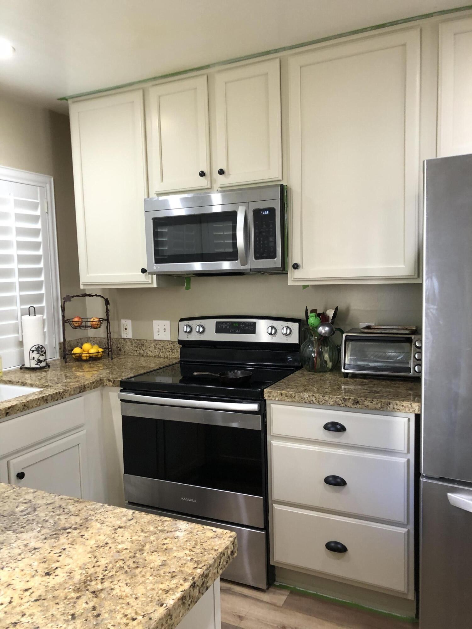 a kitchen with granite countertop cabinets stainless steel appliances and a sink