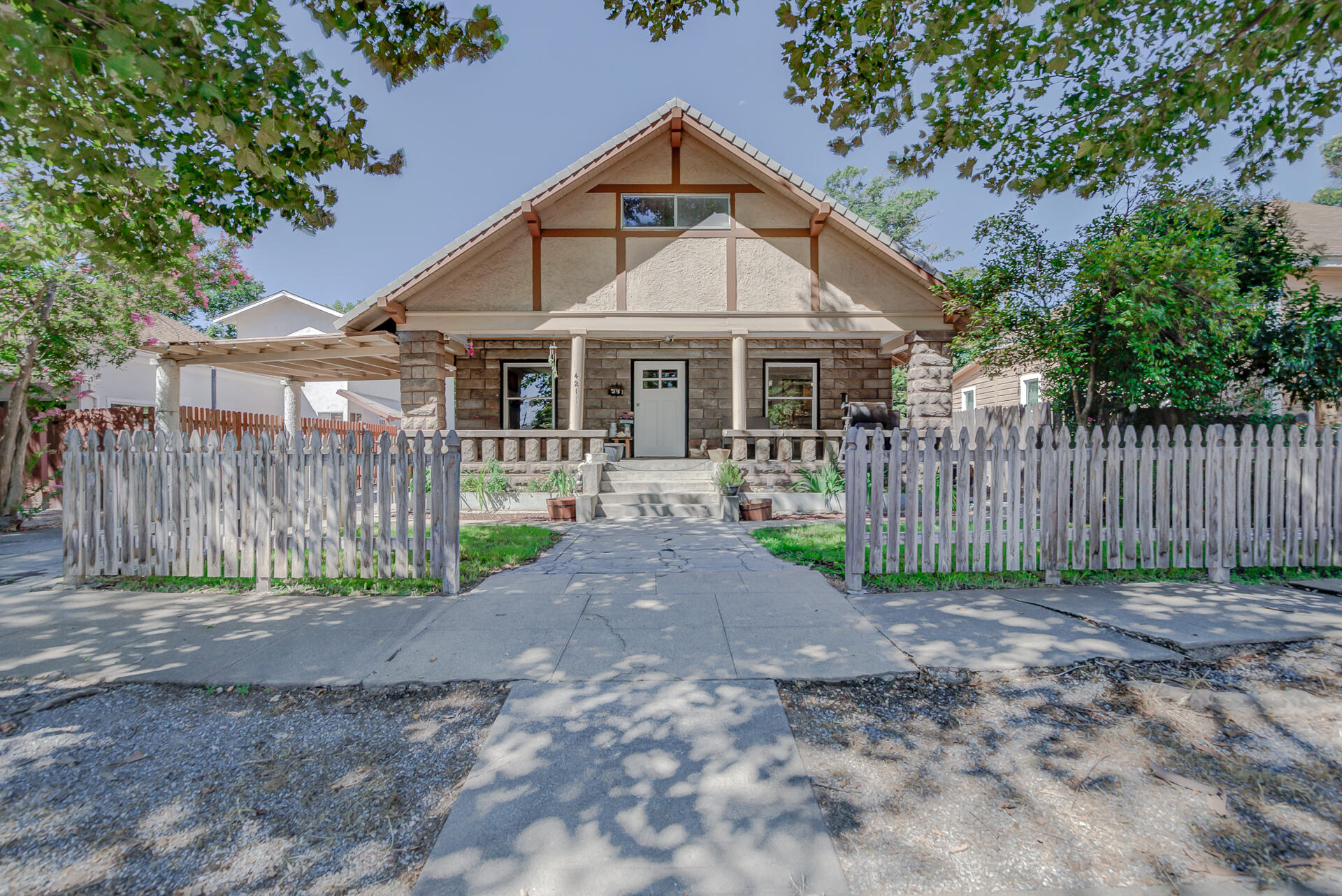 a view of a small yard in front of a house with wooden fence