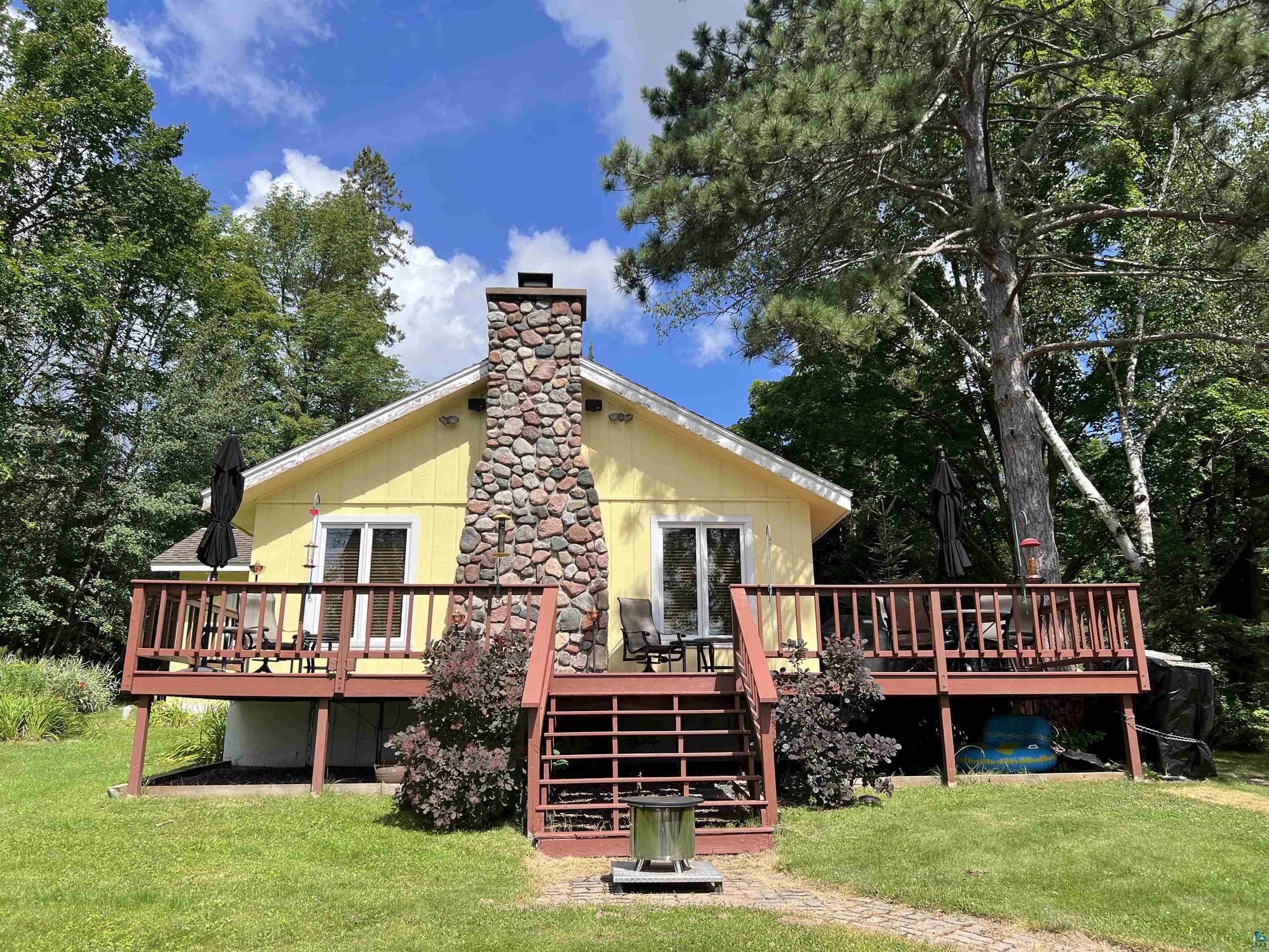 Back of property with a deck and a lawn