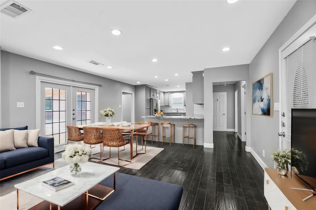 a living room with stainless steel appliances furniture and a flat screen tv