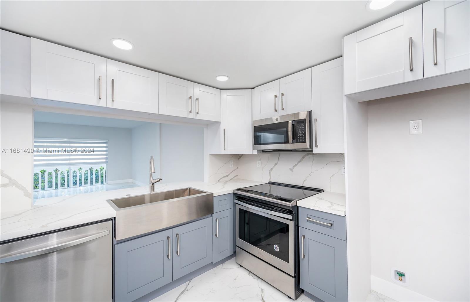 a kitchen with sink a microwave and cabinets