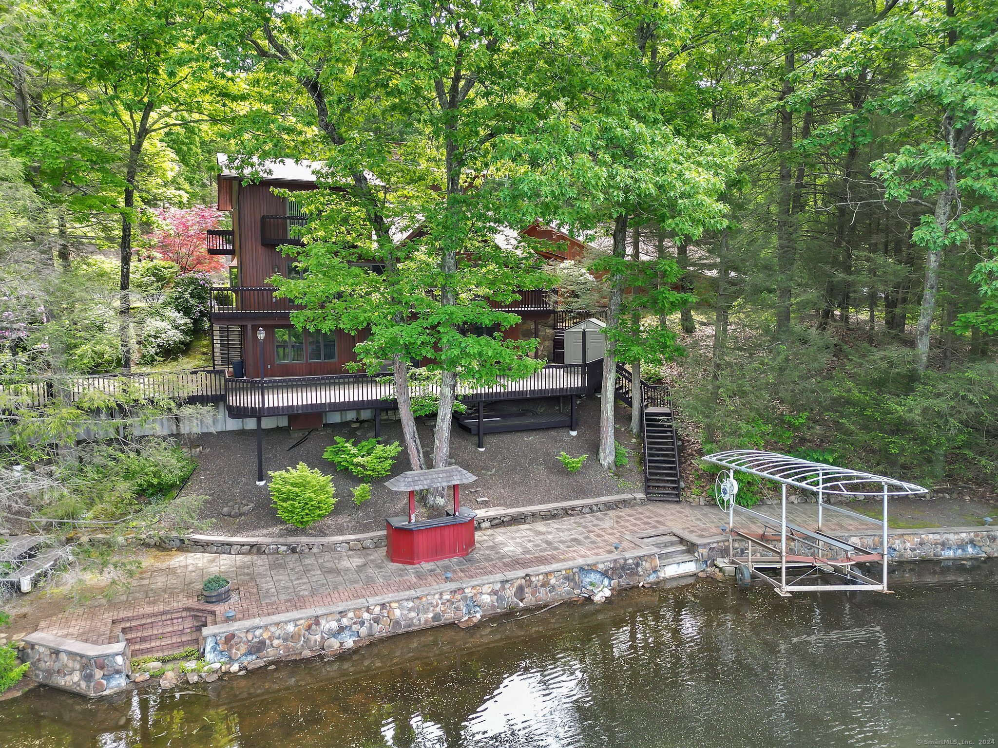 a view of small yard with large trees and plants