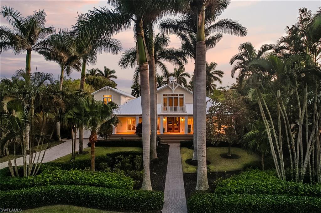 View of front of house with expansive entry and lush landscape live in your Naples Dream Home!