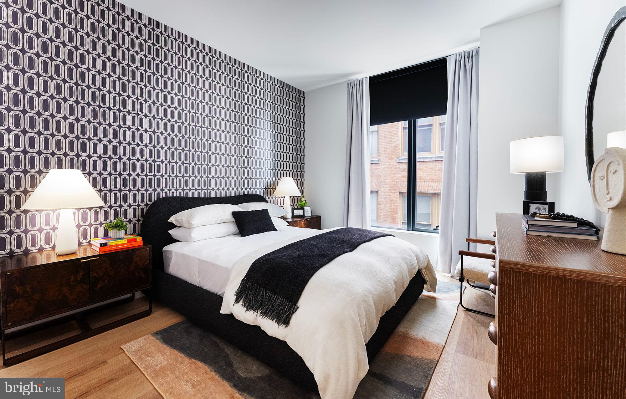 a bedroom with a bed and a flat tv screen on dresser