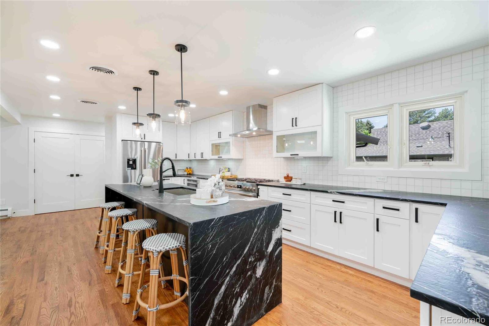 a kitchen with granite countertop a sink a center island stainless steel appliances and cabinets