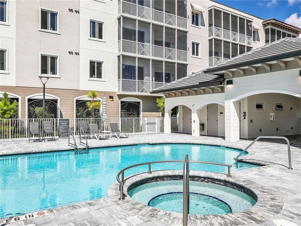 View of pool with a patio area and a hot tub