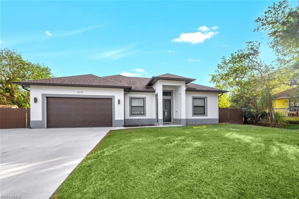 Prairie-style home with a garage and a front yard