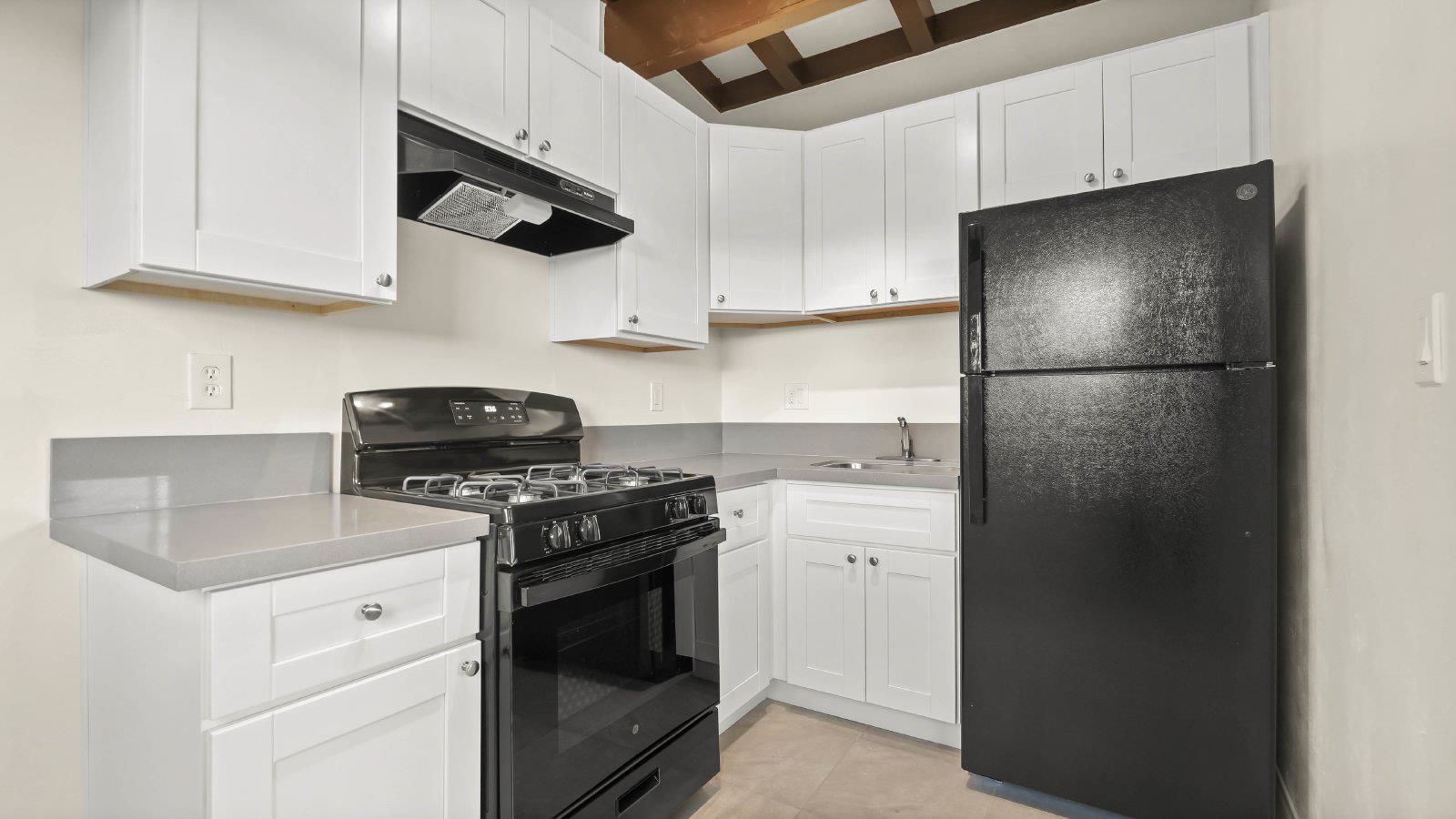 a kitchen with stainless steel appliances granite countertop white refrigerator sink a stove and white cabinets