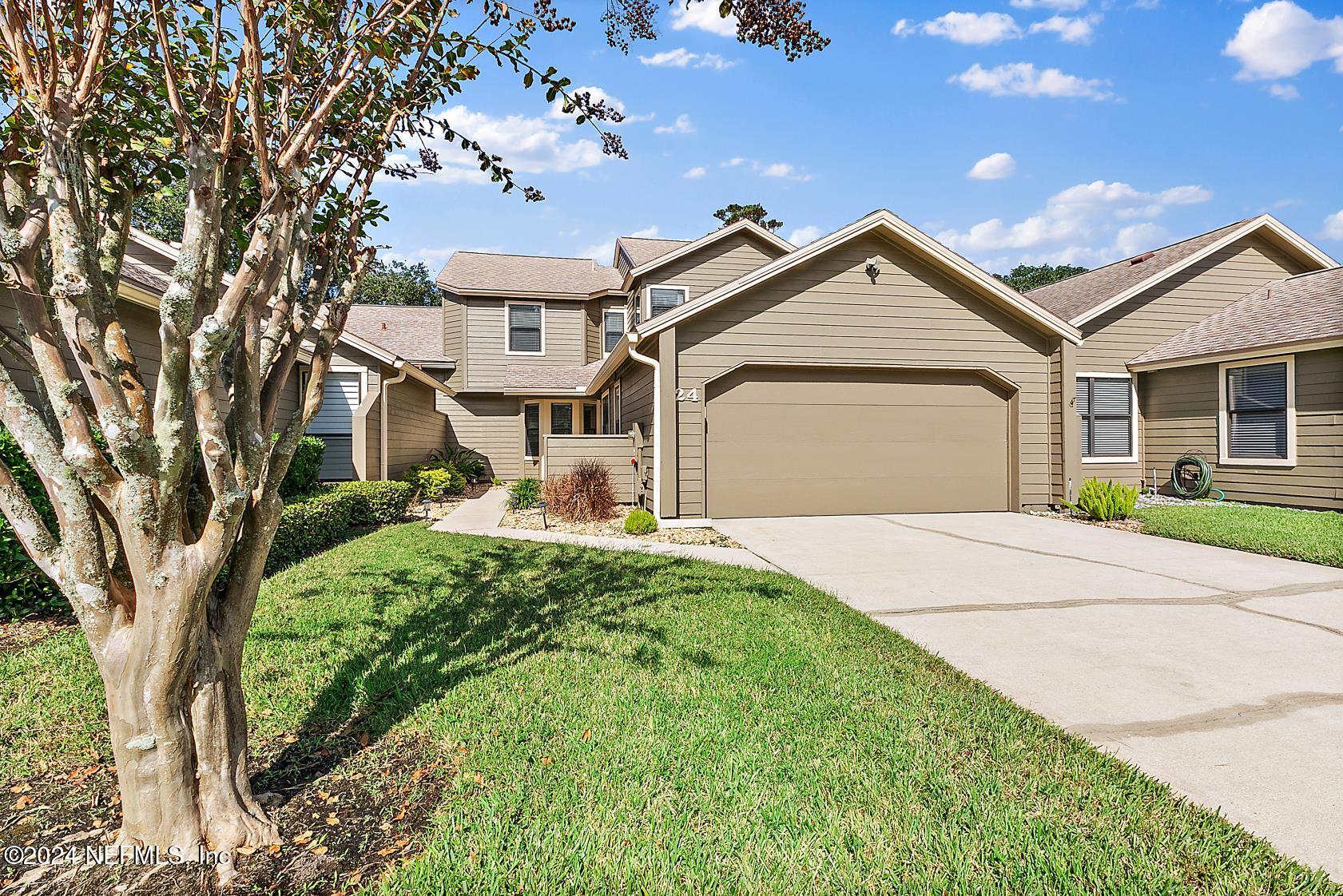 a front view of a house with yard and garage