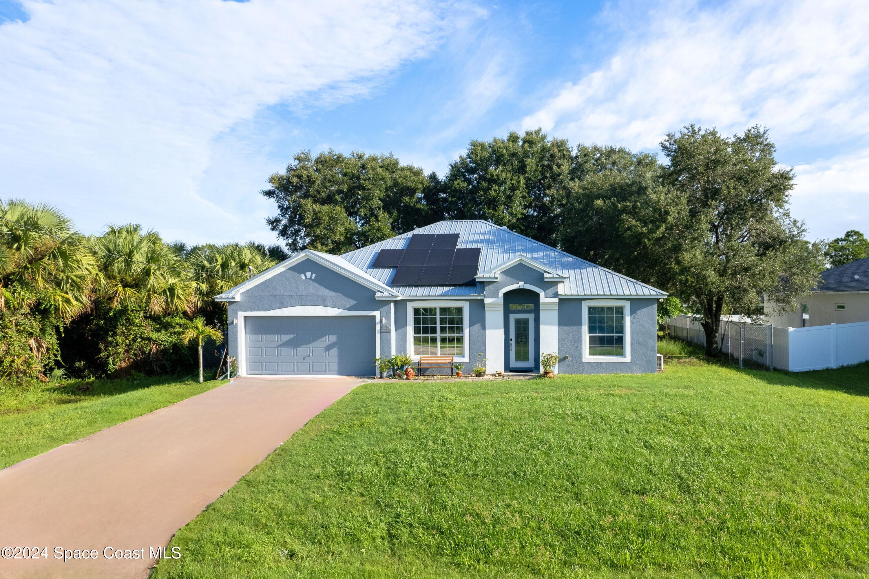 a front view of a house with yard and green space