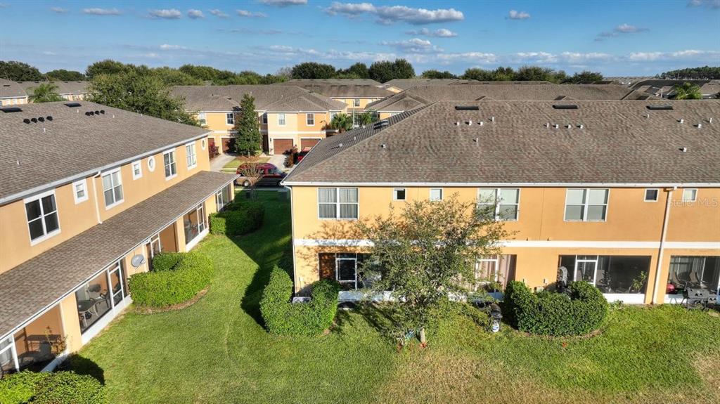 an aerial view of multiple houses with a yard