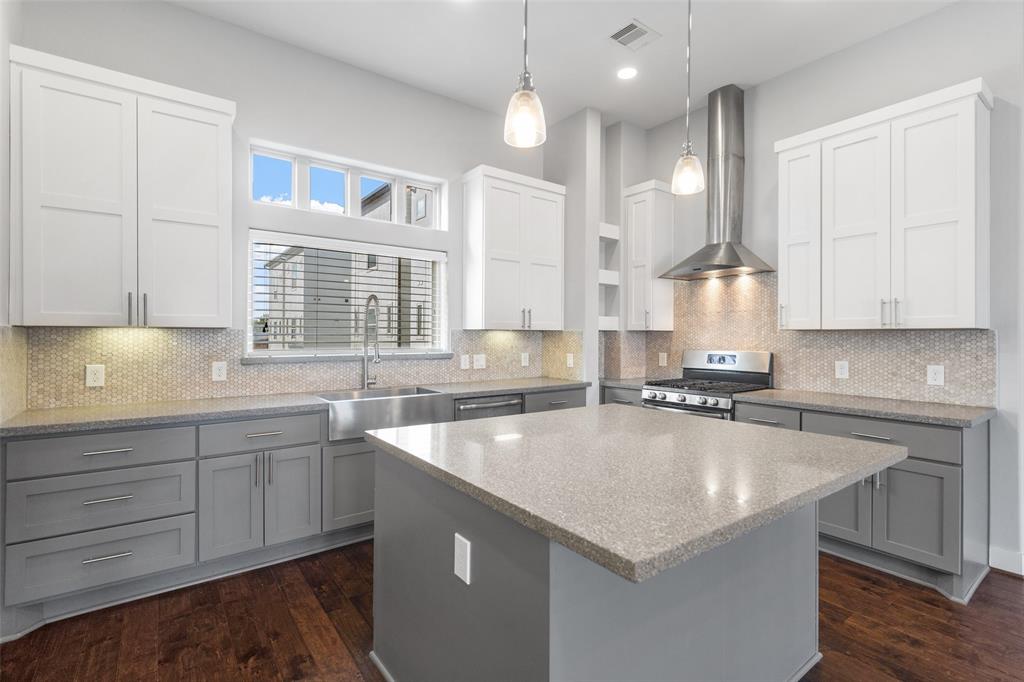 a kitchen with a sink a center island cabinets and a window