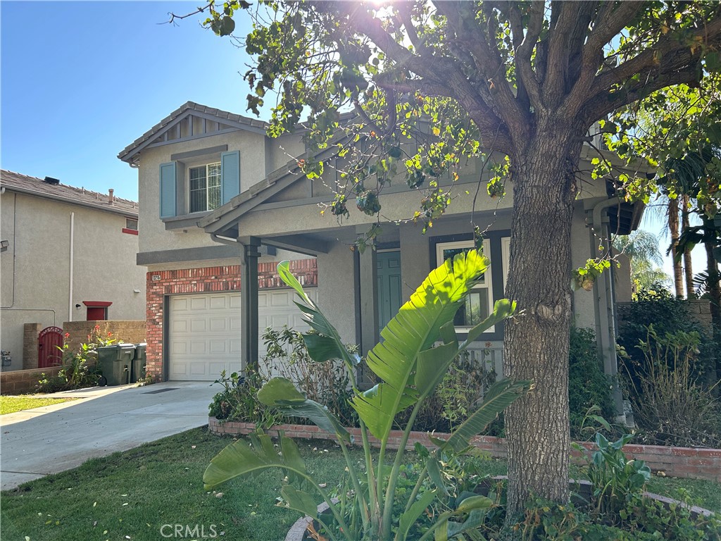 a view of a house with a tree and a garden